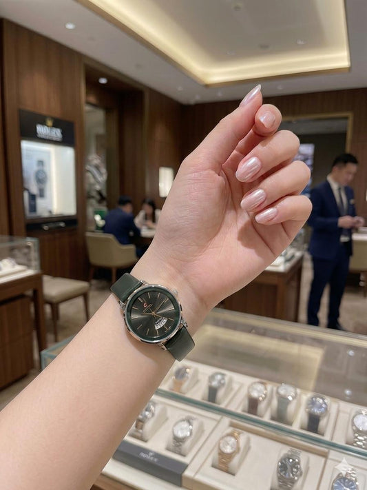 Hand wearing a watch with a blurred background of a store interior