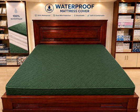 Green mattress cover on a bed with 'Waterproof Mattress Cover' branding in a store setting.
