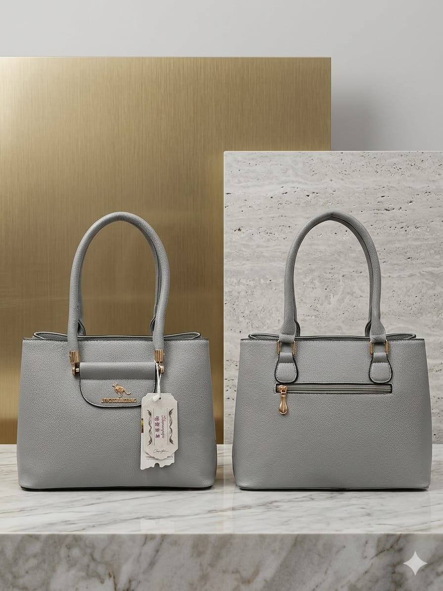 Two gray handbags on a marble surface with a gold and white background