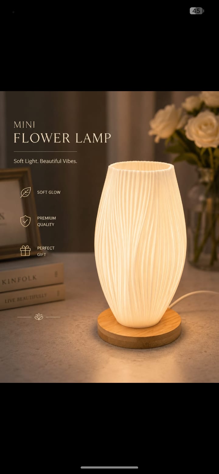 Mini flower lamp with wooden base on a surface, surrounded by books and flowers.