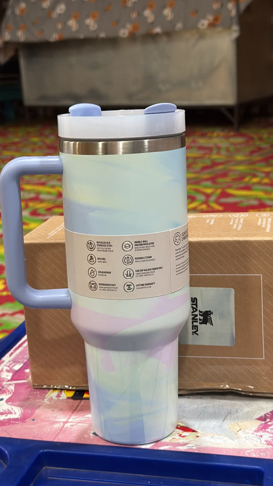 Colorful insulated mug with handle on a patterned surface